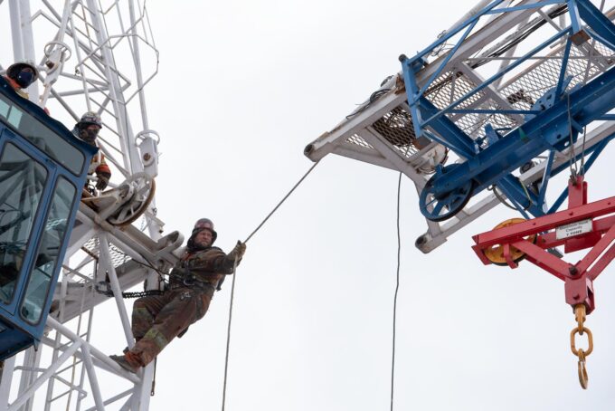 Worker reaches out to remove boom of crane in Toronto