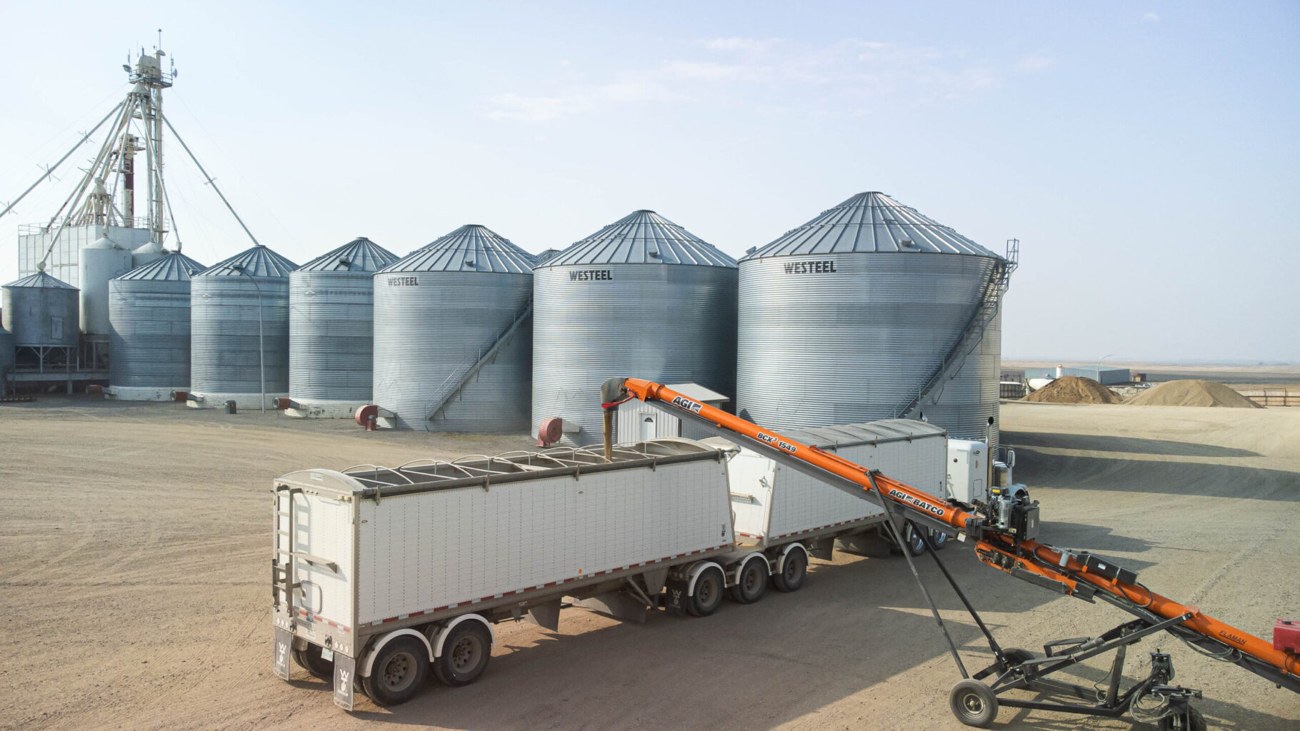 AGI Silos holding grain are used to load truck in rural Saskatchewan