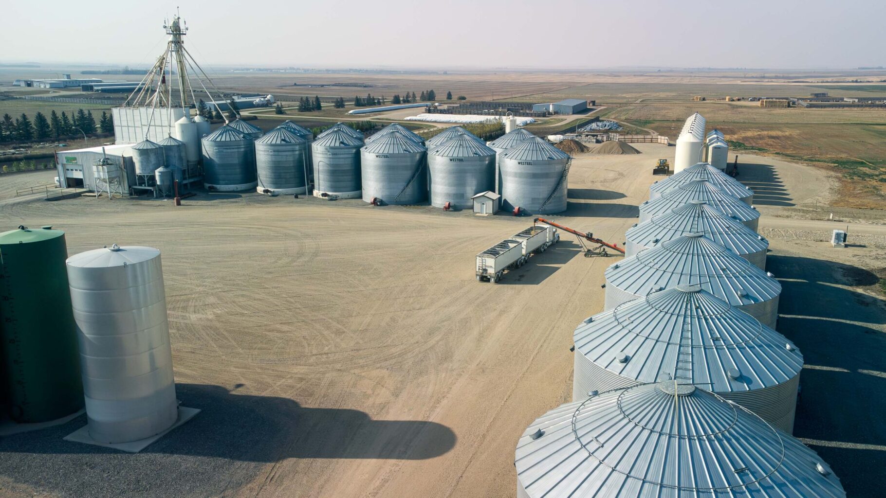 AGI Silos holding grain are used to load truck in rural Saskatchewan