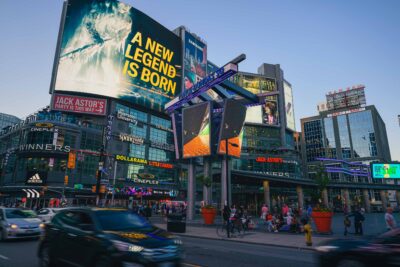 Billboard display at Yonge and Dundas Square featuring behind-the-scenes image of St. Patrick Station during renovations