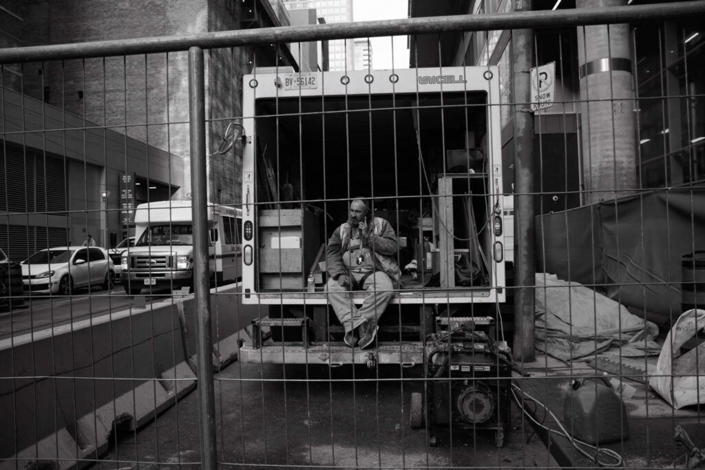 Construction worker talking on the phone while on a break in Downtown Toronto Street Photography 2024 by Nick Wons